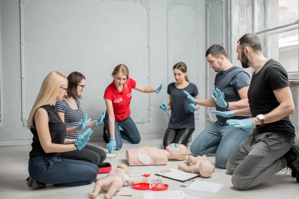 Instructor supervising CPR training on adult manikin