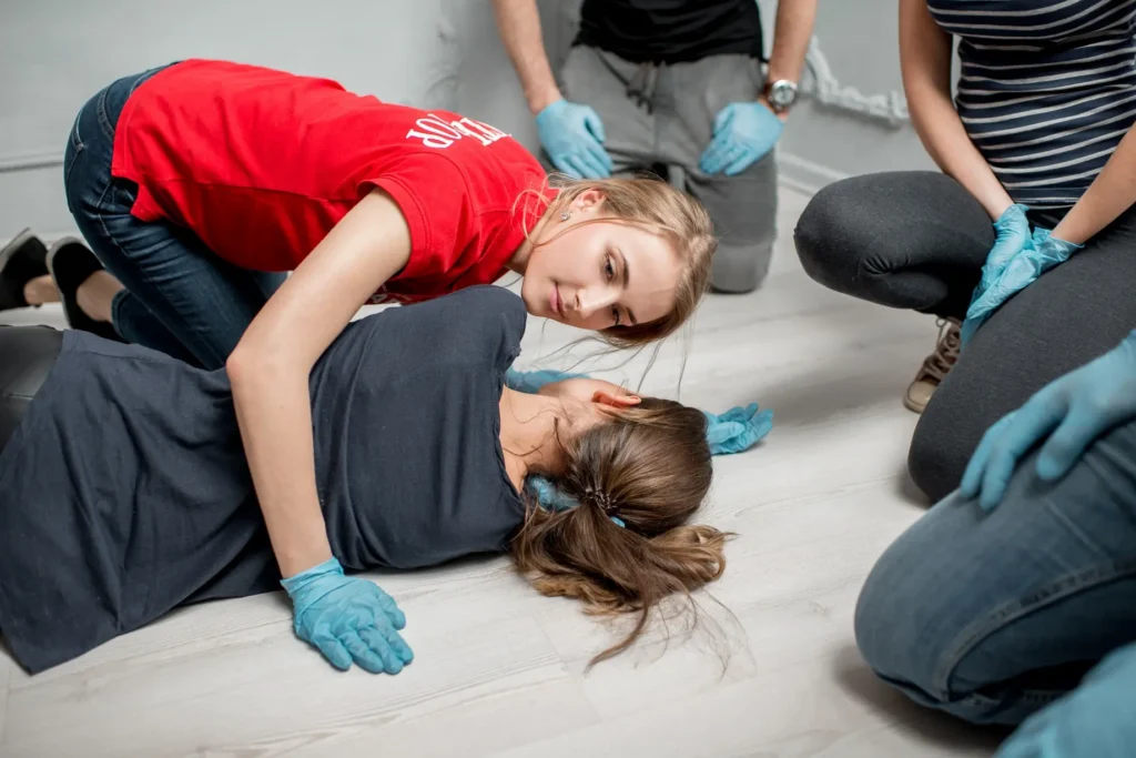 First aid instructor assessing breathing in emergency response exercise