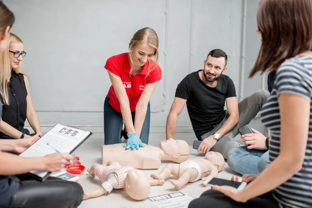 Students practicing CPR on adult and infant manikins during first aid course